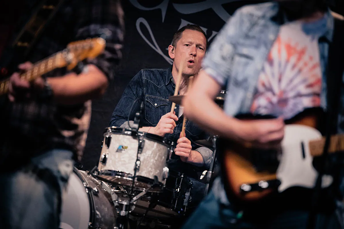 Drummer seen between the band's guitarists