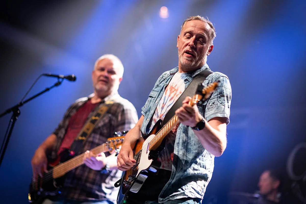 Guitarist singing and playing during a Creedence Experience concert